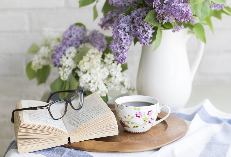 side table with lavender flowers a book and a cup of coffee
