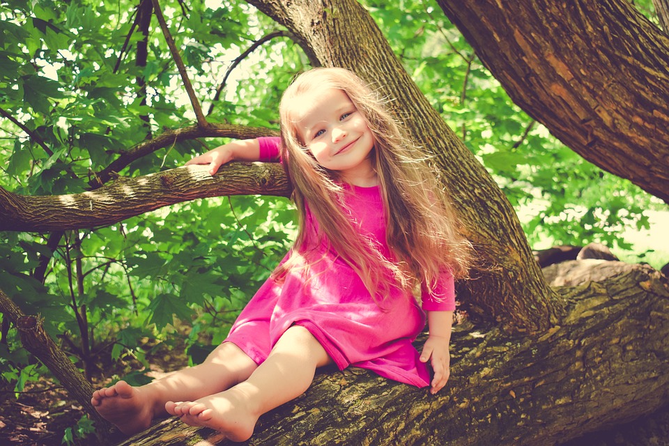 smiling girl sitting in tree
